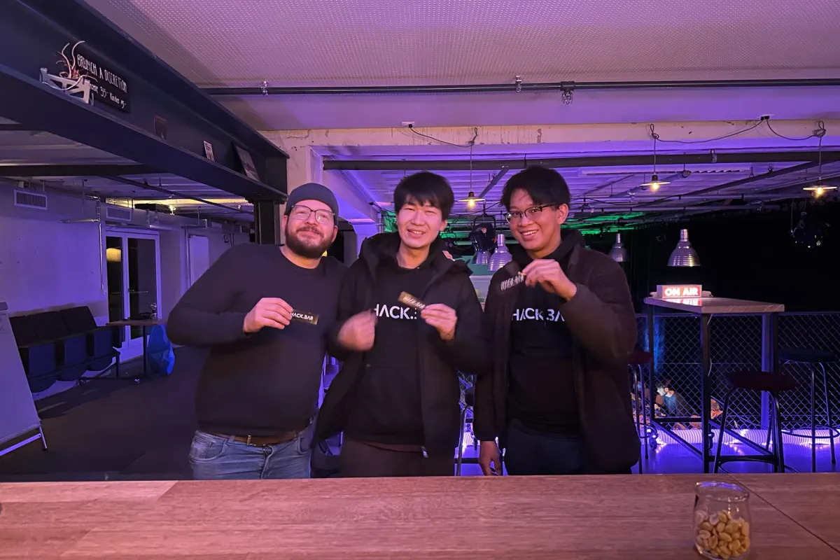 HACK.BARのステッカーを手にした3人